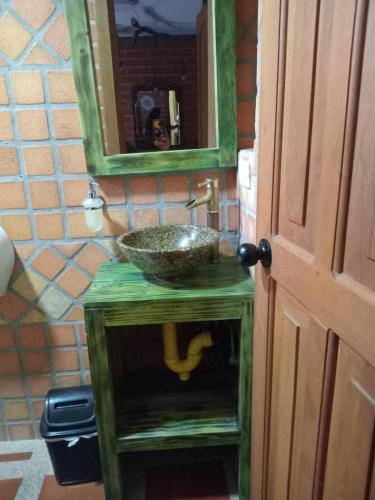 a bathroom with a green sink and a mirror at Hotel Spa Bliss Guatape in Guatapé