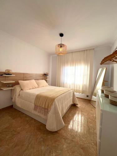 a bedroom with a large bed and a chandelier at Rincón Del Sol in Frigiliana