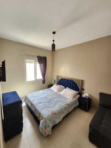 a bedroom with a bed and a window and a couch at Comfortable apartment near the Airport in Marrakech