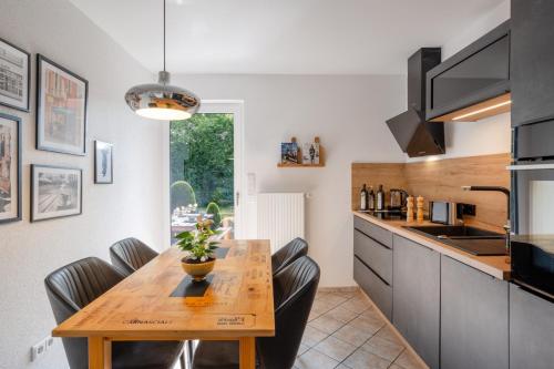 a kitchen with a wooden table and black chairs at Elegant Eifel Studio I Hiking I Kitchen I Terrace in Daun