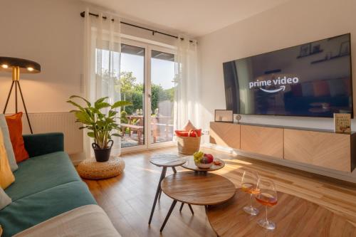 a living room with a couch and a tv at Elegant Eifel Studio I Hiking I Kitchen I Terrace in Daun
