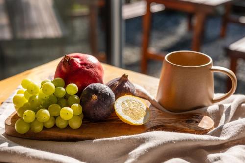 a plate of fruit and a cup on a table at Elegant Eifel Studio I Hiking I Kitchen I Terrace in Daun