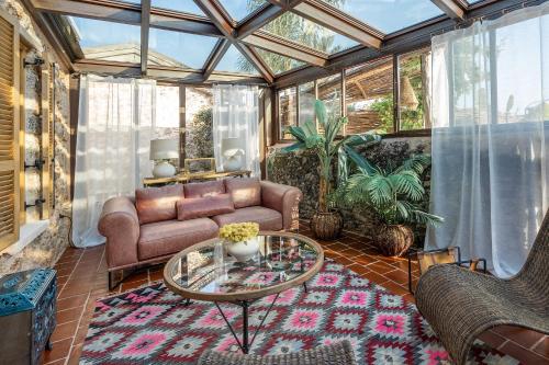 a conservatory with a couch and a glass table at Kassandra Heritage in Fethiye
