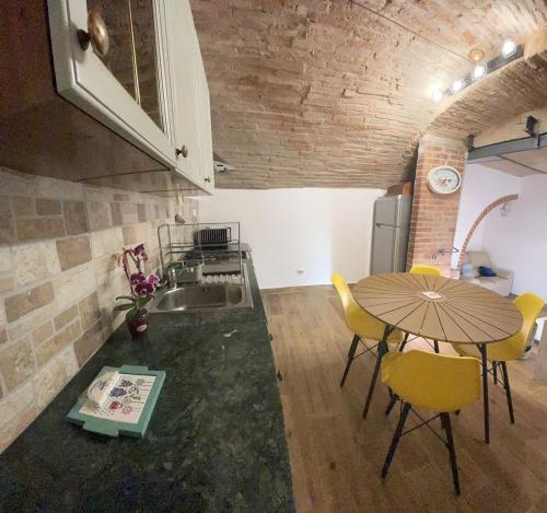 a kitchen with a table and chairs in a room at Casa di Duccio in Montone