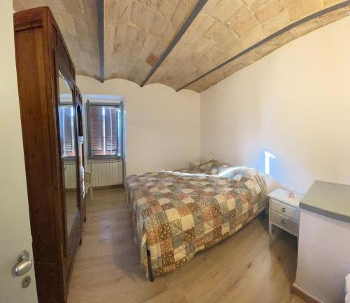 a bedroom with a bed and a wooden floor at Casa di Duccio in Montone