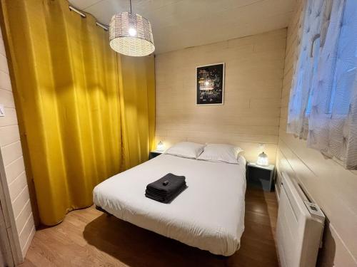 Cette chambre comprend un lit avec une mallette noire. dans l'établissement Alonville 2pers Wifi and Tv, à Nantes