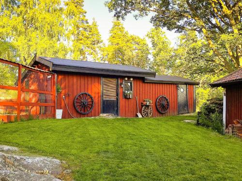 a red barn with a black door and a yard at 4 star holiday home in Märsta in Märsta