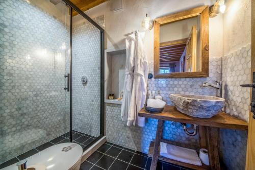a bathroom with a sink and a glass shower at Kassandra Heritage in Fethiye