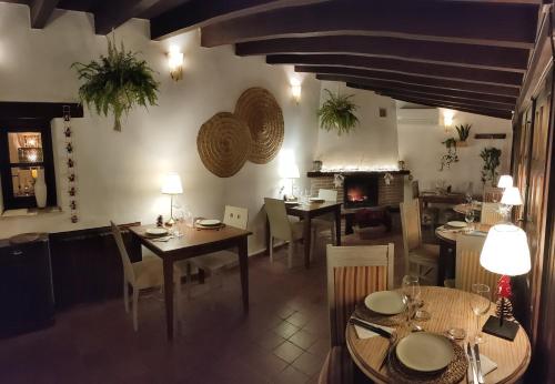 Un comedor con mesas y sillas y una chimenea. en Hotel La Casa del Canónigo, en Caracenilla