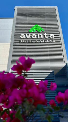 a sign on the side of a building with pink flowers at Avanta Hotel & Villas Querétaro in Santa Rosa de Jáuregui