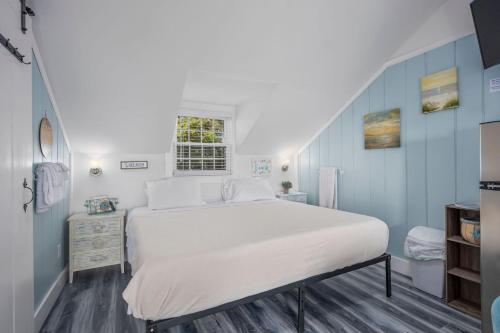 a bedroom with a large white bed and blue walls at Seaside Cottages - Cottage 32A - Seaside Too in South Yarmouth
