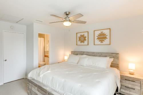 a bedroom with a white bed and a ceiling fan at Steps to Indian Wells Condo with Golf Course Views! in La Quinta
