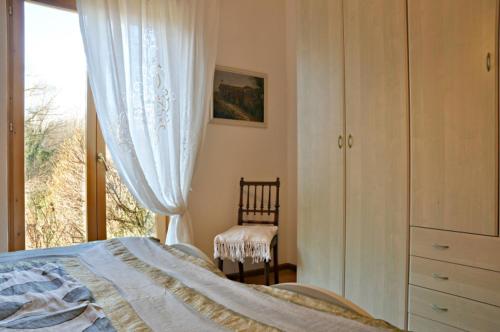 a bedroom with a bed and a window and a chair at De Bati in Belluno
