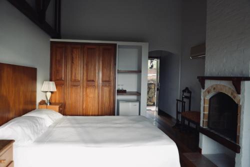 a bedroom with a large bed and a fireplace at CARDON Posada Boutique in Punta del Este
