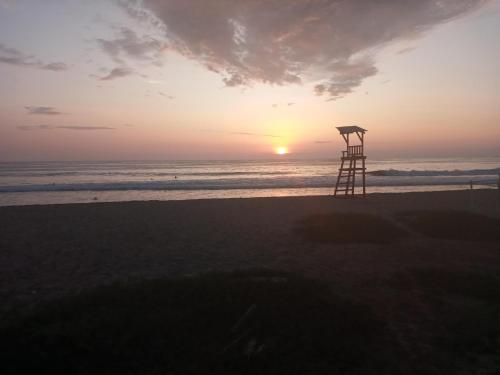 a lifeguard tower on the beach at sunset at The Lookout Beach Hotel in San Lorenzo