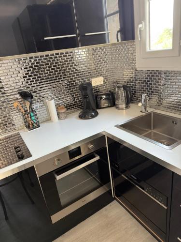 une cuisine avec un évier et un plan de travail dans l'établissement Charmant studio cœur de ville Saint Tropez, à Saint-Tropez