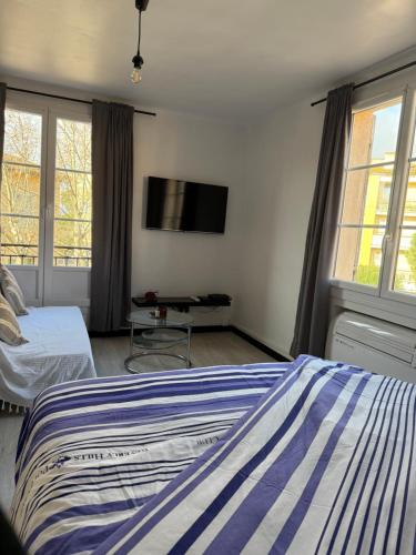 une chambre avec deux lits et une télévision à écran plat dans l'établissement Charmant studio cœur de ville Saint Tropez, à Saint-Tropez