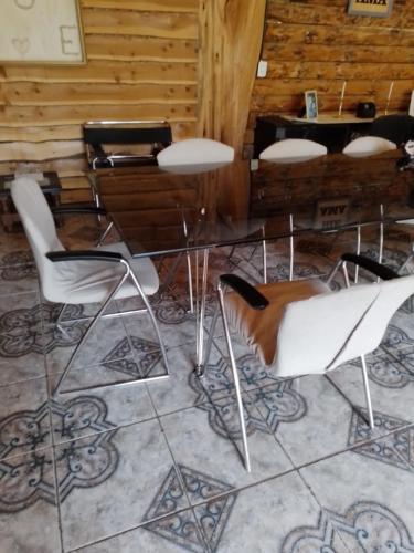 a table and chairs in a room with a piano at Puenteromano in Golondrinas