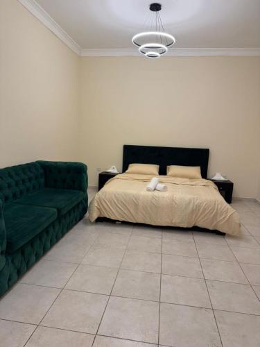 a bedroom with a bed and a green couch at Royal Line Vacation Homes Rental LLC in Dubai
