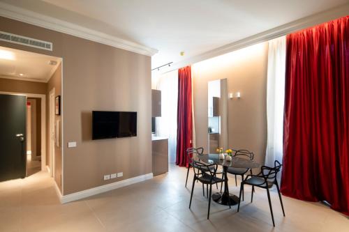 a dining room with red curtains and a table and chairs at Seven Suites Apartments - Via Matteotti 178 in Sanremo