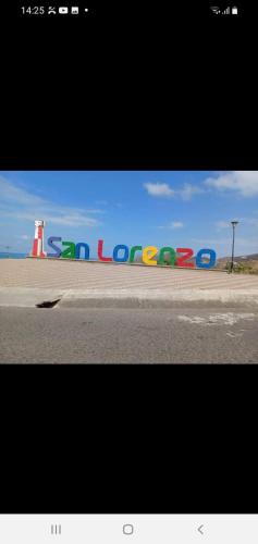 a picture of a sign with a lighthouse and a street at The Lookout Beach Hotel in San Lorenzo