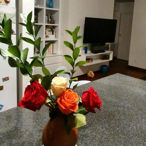 a vase filled with roses sitting on a table at Chambre créole et sa salle de bain chez Michelle in La Désirade