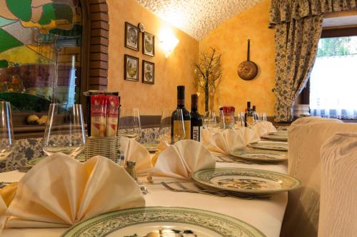 a table with plates and bottles of wine on it at Hotel Aurora in Cimego