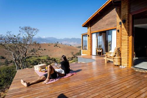 two people sitting on the deck of a house at Refúgio Terras Altas in Itanhandu