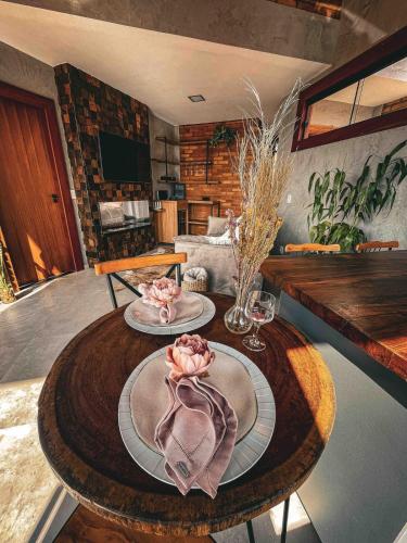 a table with two plates with flowers on top of it at Refúgio Terras Altas in Itanhandu