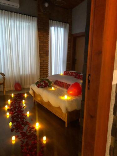 a bedroom with a bed with candles on the floor at Refúgio Terras Altas in Itanhandu