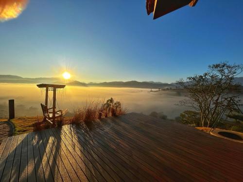 a view of the sun rising over a foggy valley at Refúgio Terras Altas in Itanhandu