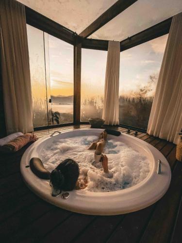 a baby laying in a bath tub in front of a window at Refúgio Terras Altas in Itanhandu