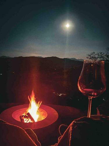 a glass of wine sitting next to a campfire at Refúgio Terras Altas in Itanhandu