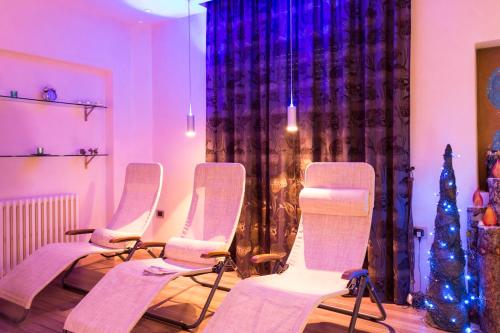a group of chairs in a room with a christmas tree at Hotel Aurora in Cimego
