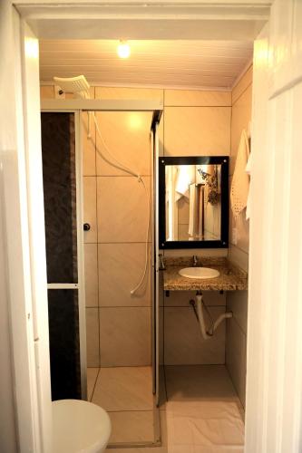 a bathroom with a sink and a shower with a mirror at Chalé dos Sonhos e Encantos em Monjolinho in Ponte Alta