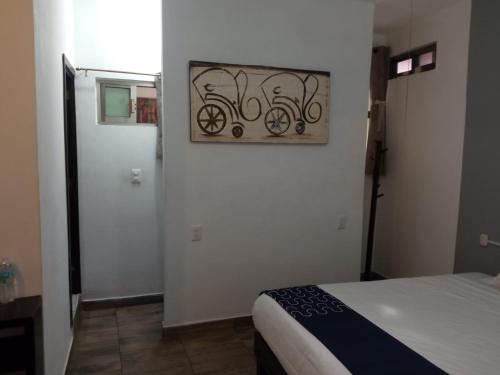 a bedroom with a bed and a painting on the wall at Hotel Gandag in Orizaba