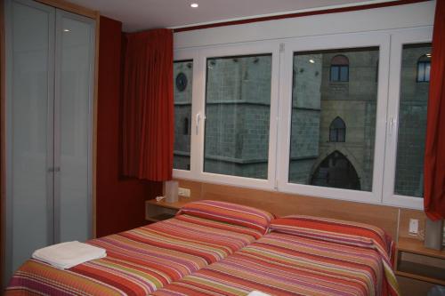 a bedroom with a bed and a large window at Ekia Pentsioa in Zarautz