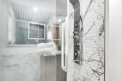 a white bathroom with a shower and a sink at 6 Mi to Spectrum Center: Spacious Getaway w/ Deck in Charlotte