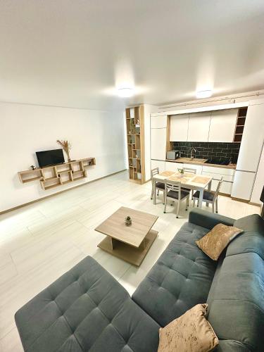 a living room with a blue couch and a table at B2 Boutique Apartments in Năvodari