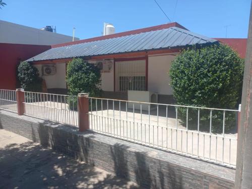 a white fence in front of a house at Magnífica casa con cochera privada in Luján