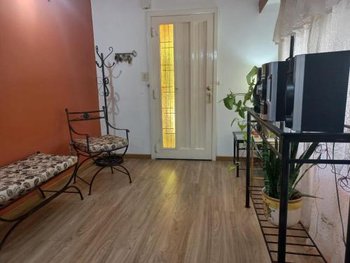 a living room with a tv and a couch and a chair at Magnífica casa con cochera privada in Luján