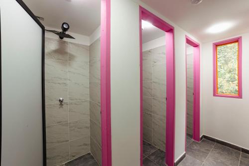 a walk in shower in a bathroom with pink doors at Isla de pascua - Jardín - Hostel in Jardin