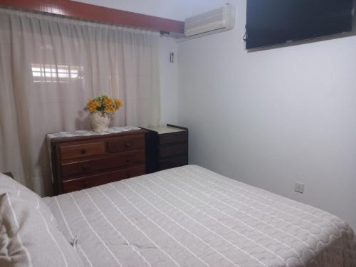a bedroom with a bed and a dresser and a window at Magnífica casa con cochera privada in Luján