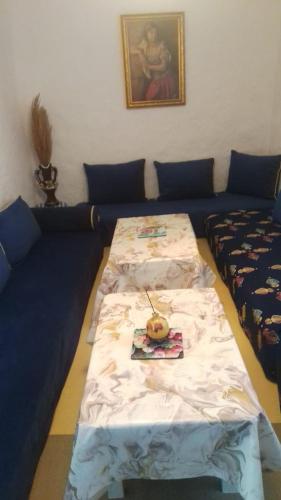 a room with two beds and a table with a plate on it at Casa de campo in Al Hoceïma