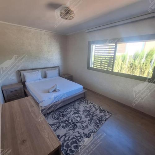 a bedroom with a bed and a window and a rug at Casa Serenity Villa Taghazout Bay Tamda in Taghazout