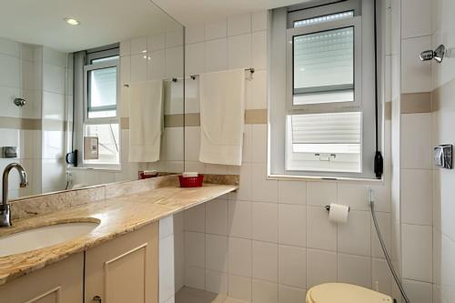 um banheiro com uma pia e um espelho em Copacabana ampla vista mar no Rio de Janeiro