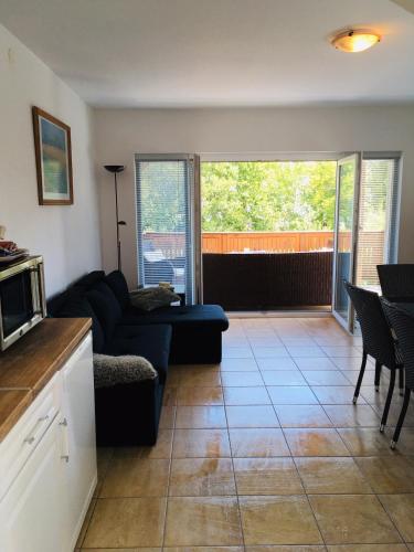 a living room with a couch and a tv at Kertből a Balatonra in Révfülöp