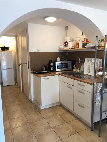 a kitchen with white cabinets and a counter top at Kertből a Balatonra in Révfülöp