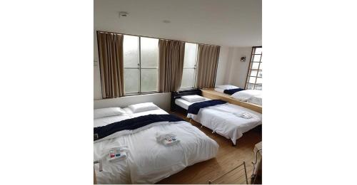 a bedroom with two beds and a window at Nagoya Hostel The Three Smiles / Vacation STAY 13462 in Nagoya