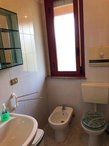 a bathroom with a sink and a toilet and a window at Albergo BELVEDERE in Santa Cristina Gela